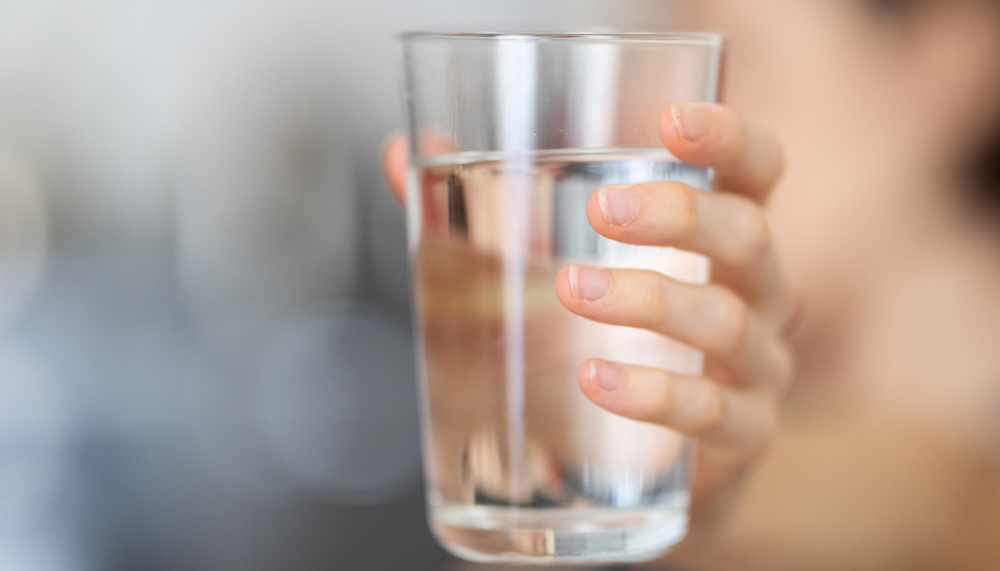 femme qui tient un verre d'eau